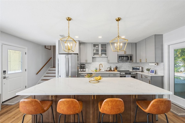 4521 S Cooper Pl, Tampa, FL 33611 - kitchen with gray cabinets, appliances with stainless steel finishes, a chandelier, and recessed lighting