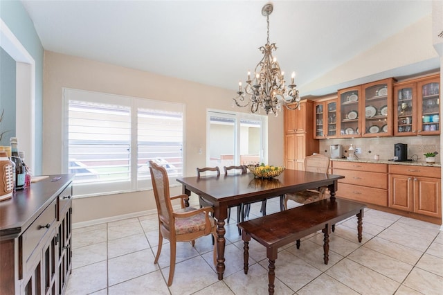 835 Symphony Isles Blvd, Apollo Beach, FL 33572 - dining space with lofted ceiling, light tile patterned floors, and a chandelier