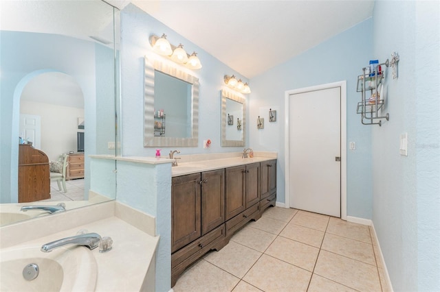 835 Symphony Isles Blvd, Apollo Beach, FL 33572 - bathroom featuring vaulted ceiling, double vanity, a garden tub, and tile patterned flooring