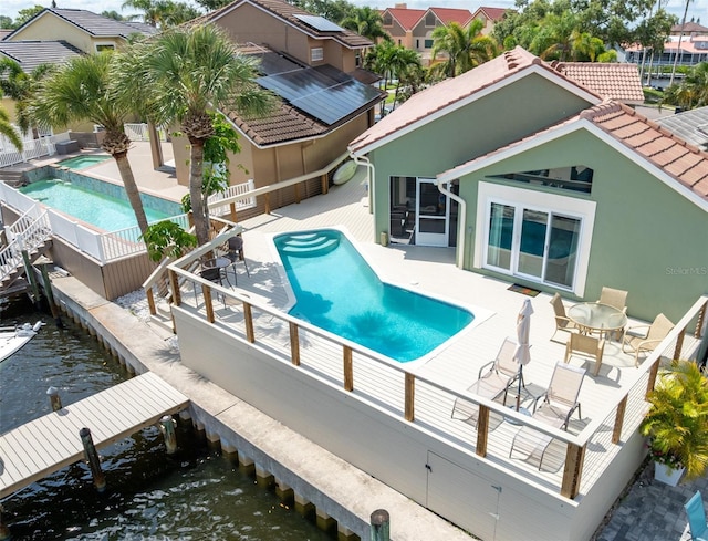 835 Symphony Isles Blvd, Apollo Beach, FL 33572 - view of swimming pool featuring a fenced backyard, a dock, a patio, and a wooden deck