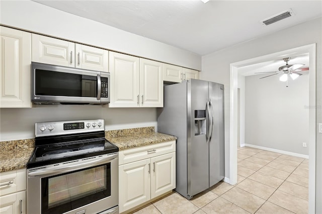 129 Magnolia Ave, Seffner, FL 33584 - kitchen featuring stainless steel appliances, light tile patterned floors, a ceiling fan, and light stone countertops