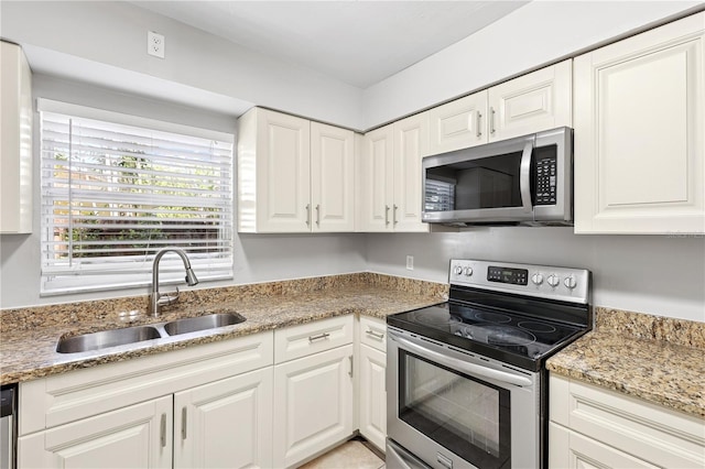 129 Magnolia Ave, Seffner, FL 33584 - kitchen with appliances with stainless steel finishes, white cabinets, and light stone counters