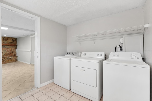 129 Magnolia Ave, Seffner, FL 33584 - laundry area featuring washer and dryer, light tile patterned floors, and a textured ceiling
