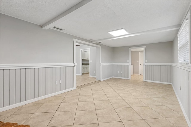 129 Magnolia Ave, Seffner, FL 33584 - unfurnished room featuring a textured ceiling, light tile patterned floors, and wainscoting