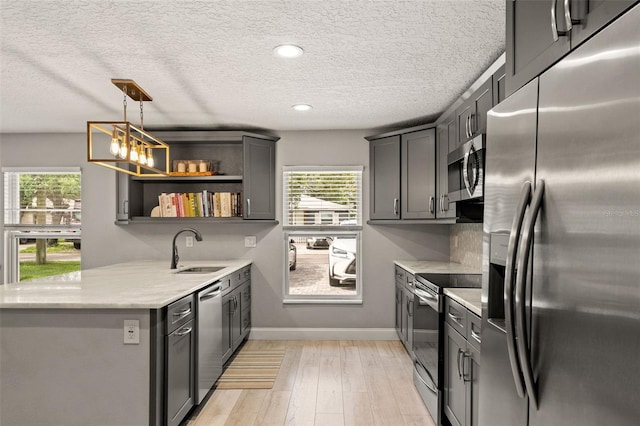 3135 W Varn Ave, Tampa, FL 33611 - kitchen featuring stainless steel appliances, healthy amount of natural light, open shelves, a textured ceiling, and light wood-type flooring