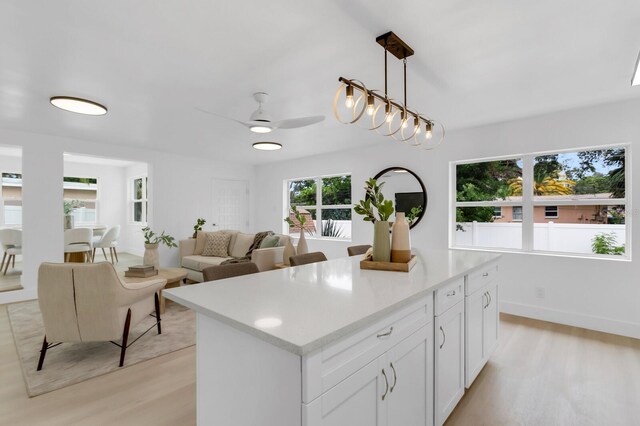3381 19th Pl SW, Largo, FL 33774 - kitchen with light wood-style floors, a center island, light countertops, and decorative light fixtures