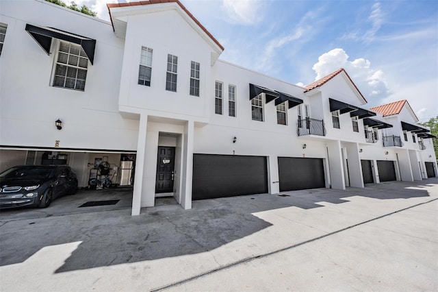 3210 W Horatio St Unit 9, Tampa, FL 33609 - view of front of house featuring an attached garage, stucco siding, driveway, and a tile roof