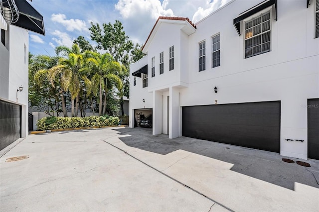 3210 W Horatio St Unit 9, Tampa, FL 33609 - view of side of property with stucco siding, an attached garage, and a tiled roof