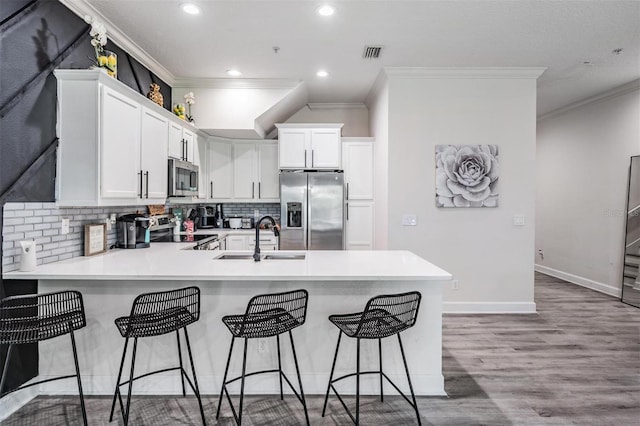 3210 W Horatio St Unit 9, Tampa, FL 33609 - kitchen with stainless steel appliances, ornamental molding, a peninsula, backsplash, and recessed lighting