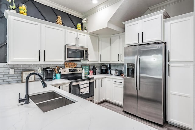 3210 W Horatio St Unit 9, Tampa, FL 33609 - kitchen with appliances with stainless steel finishes, crown molding, white cabinetry, decorative backsplash, and recessed lighting