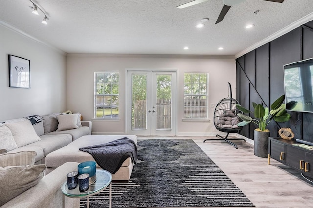3210 W Horatio St Unit 9, Tampa, FL 33609 - living area with ornamental molding, ceiling fan, light wood-style floors, french doors, and a textured ceiling