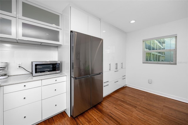 4050 4th St N Unit 116, Saint Petersburg, FL 33703 - kitchen featuring stainless steel appliances, dark wood-style flooring, white cabinets, glass insert cabinets, and recessed lighting