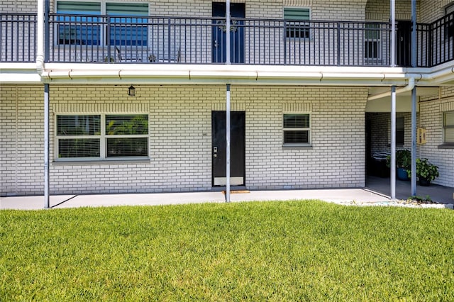 4050 4th St N Unit 116, Saint Petersburg, FL 33703 - property entrance with brick siding, a lawn, and a balcony