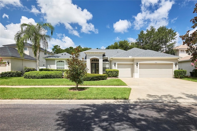 15412 Carrillon Estates Blvd, Tampa, FL 33625 - view of front of home featuring a garage, concrete driveway, stucco siding, and a front yard