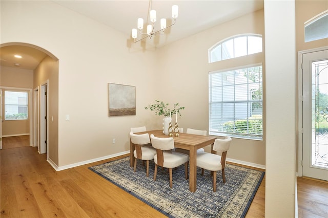 15412 Carrillon Estates Blvd, Tampa, FL 33625 - dining room with arched walkways, a chandelier, and light wood-style flooring