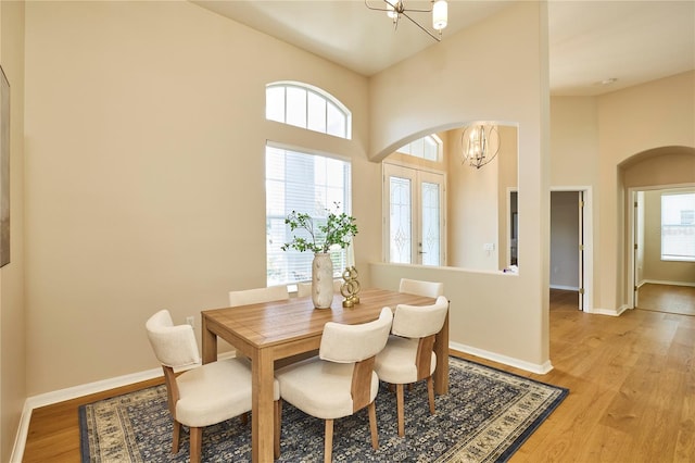 15412 Carrillon Estates Blvd, Tampa, FL 33625 - dining room with a chandelier, arched walkways, plenty of natural light, light wood finished floors, and a towering ceiling
