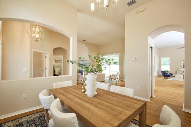15412 Carrillon Estates Blvd, Tampa, FL 33625 - dining space featuring arched walkways, a chandelier, and light wood-type flooring