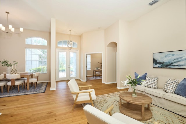 15412 Carrillon Estates Blvd, Tampa, FL 33625 - living room featuring a chandelier, arched walkways, and light wood finished floors