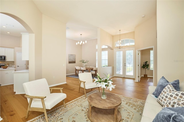 15412 Carrillon Estates Blvd, Tampa, FL 33625 - living room with a chandelier, a high ceiling, light wood-style floors, and arched walkways