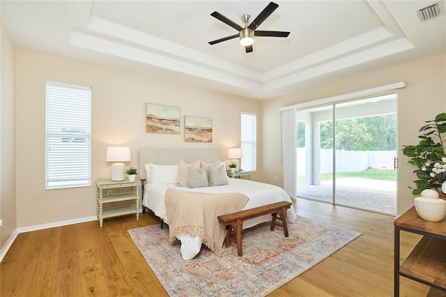 15412 Carrillon Estates Blvd, Tampa, FL 33625 - bedroom with a raised ceiling, access to exterior, and multiple windows