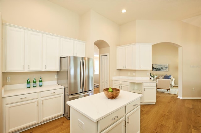 15412 Carrillon Estates Blvd, Tampa, FL 33625 - kitchen featuring freestanding refrigerator, arched walkways, light countertops, white cabinets, and a high ceiling