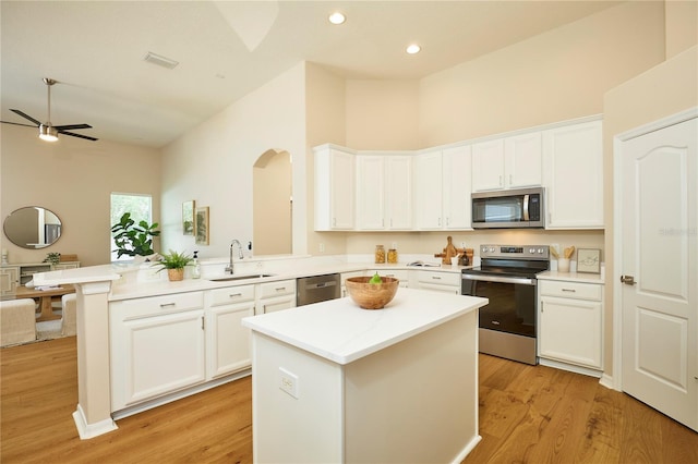 15412 Carrillon Estates Blvd, Tampa, FL 33625 - kitchen with stainless steel appliances, a peninsula, white cabinets, light countertops, and a ceiling fan