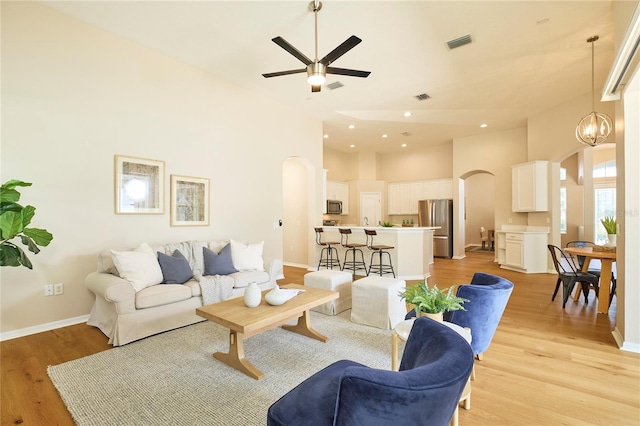 15412 Carrillon Estates Blvd, Tampa, FL 33625 - living area featuring arched walkways, a ceiling fan, light wood-style flooring, recessed lighting, and a high ceiling
