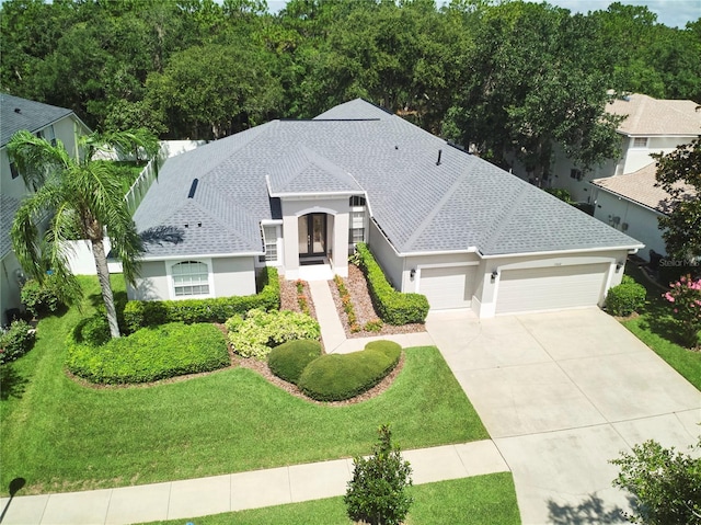 15412 Carrillon Estates Blvd, Tampa, FL 33625 - view of front facade featuring a garage, stucco siding, driveway, a front yard, and a shingled roof