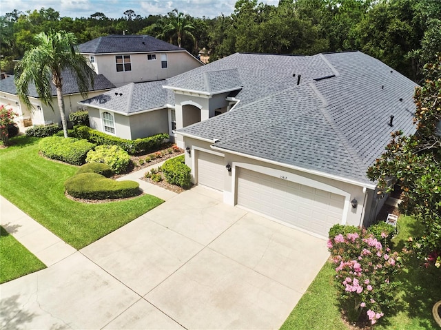 15412 Carrillon Estates Blvd, Tampa, FL 33625 - view of front of property featuring a garage, a front lawn, concrete driveway, stucco siding, and roof with shingles