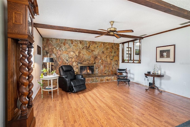 235 Old Welcome Rd, Lithia, FL 33547 - living area featuring light wood-type flooring, a ceiling fan, beam ceiling, and a stone fireplace
