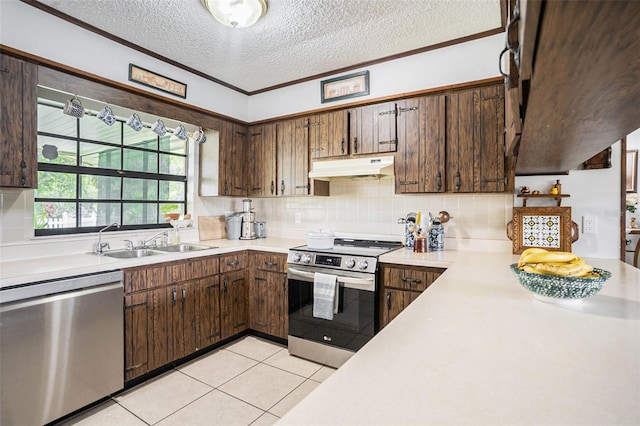 235 Old Welcome Rd, Lithia, FL 33547 - kitchen featuring appliances with stainless steel finishes, under cabinet range hood, light countertops, a textured ceiling, and decorative backsplash