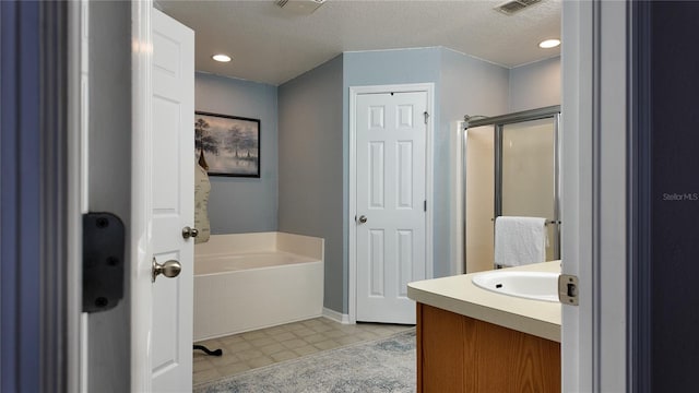 270 Planter Rd, Spring Hill, FL 34606 - bathroom with a bath, vanity, a shower stall, a textured ceiling, and recessed lighting