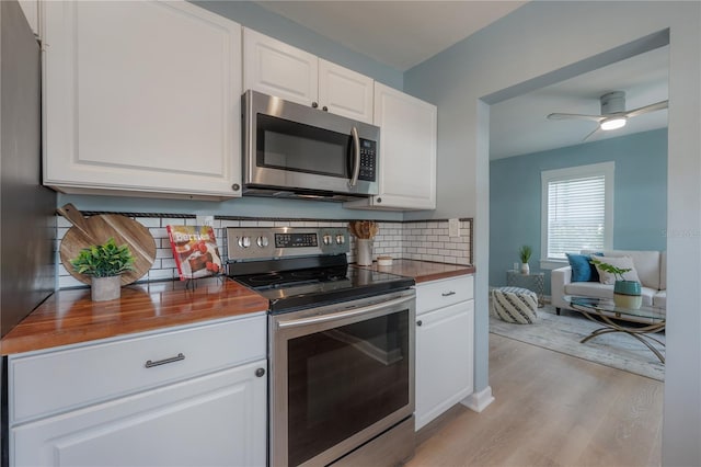 811 W Peninsular St, Tampa, FL 33603 - kitchen with stainless steel appliances, wooden counters, light wood finished floors, backsplash, and white cabinets