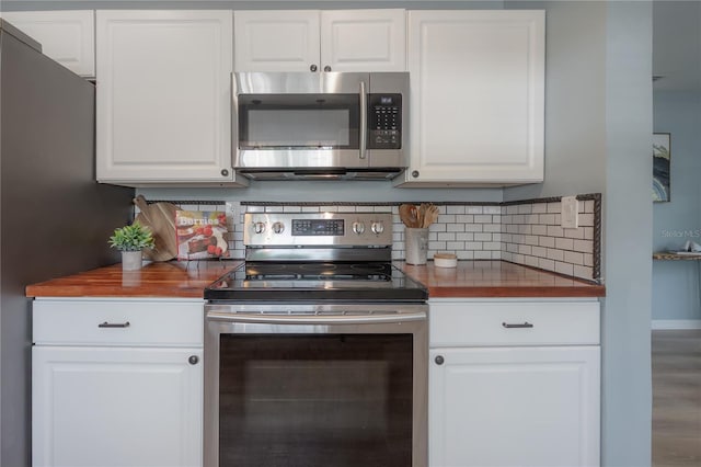 811 W Peninsular St, Tampa, FL 33603 - kitchen featuring appliances with stainless steel finishes, white cabinets, backsplash, and butcher block countertops