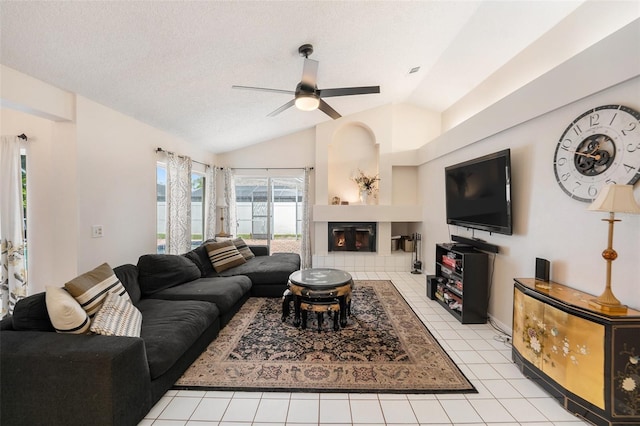 1763 Pebble Hill Ct, Palm Harbor, FL 34683 - living room featuring lofted ceiling, ceiling fan, light tile patterned floors, a glass covered fireplace, and a textured ceiling