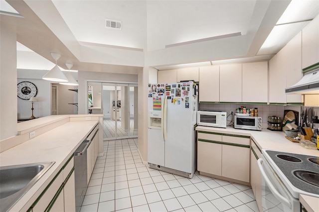 1763 Pebble Hill Ct, Palm Harbor, FL 34683 - kitchen with white appliances, light tile patterned flooring, light countertops, and tasteful backsplash