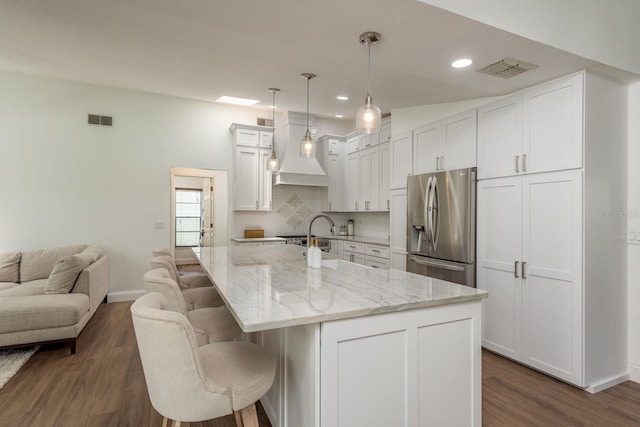 2800 Resnik Cir W, Palm Harbor, FL 34683 - kitchen featuring stainless steel fridge with ice dispenser, white cabinetry, dark wood-type flooring, a kitchen bar, and recessed lighting