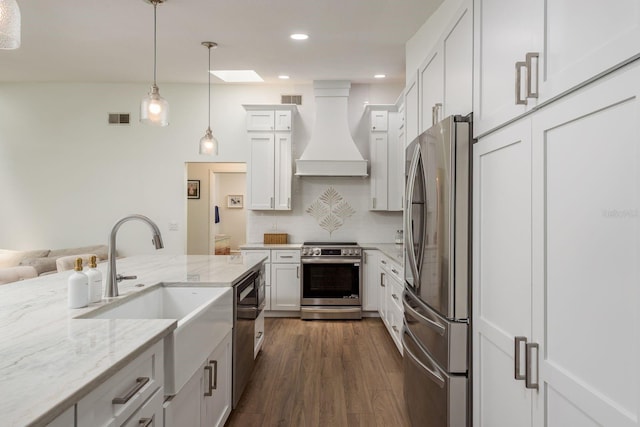 2800 Resnik Cir W, Palm Harbor, FL 34683 - kitchen featuring stainless steel appliances, custom exhaust hood, dark wood-style flooring, light stone counters, and hanging light fixtures