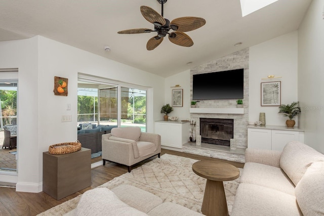 2800 Resnik Cir W, Palm Harbor, FL 34683 - living area with vaulted ceiling, ceiling fan, wood finished floors, a fireplace, and healthy amount of natural light