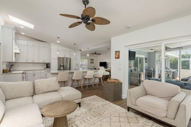 2800 Resnik Cir W, Palm Harbor, FL 34683 - living room with ceiling fan, vaulted ceiling, light wood finished floors, and healthy amount of natural light