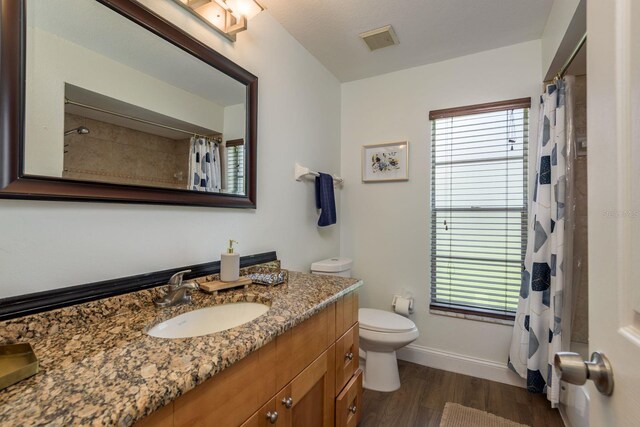 2800 Resnik Cir W, Palm Harbor, FL 34683 - full bathroom with vanity, wood finished floors, plenty of natural light, and a shower with shower curtain