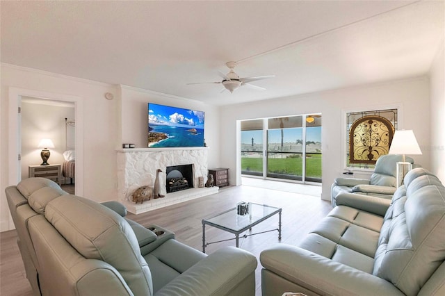 1150 Tarpon Center Dr Unit 1D, Venice, FL 34285 - living room featuring a ceiling fan, wood finished floors, ornamental molding, and a fireplace