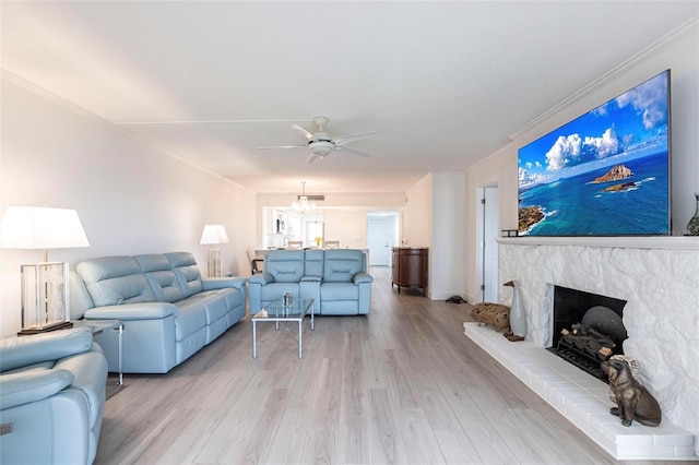 1150 Tarpon Center Dr Unit 1D, Venice, FL 34285 - living room with ceiling fan, ornamental molding, light wood finished floors, a fireplace with raised hearth, and a chandelier