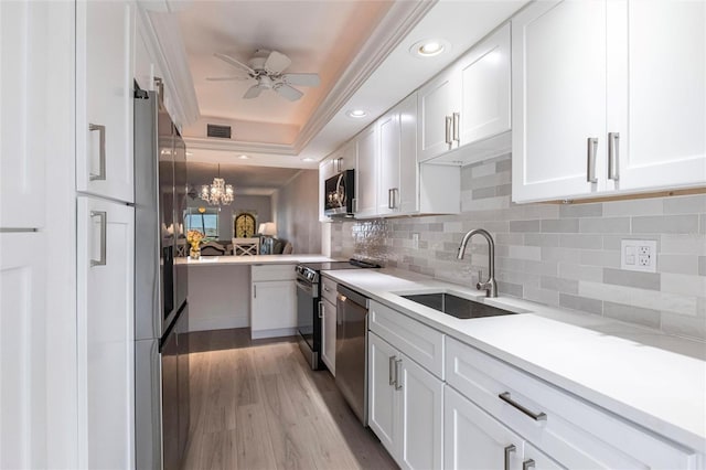1150 Tarpon Center Dr Unit 1D, Venice, FL 34285 - kitchen with stainless steel appliances, white cabinetry, decorative backsplash, ceiling fan, and light countertops