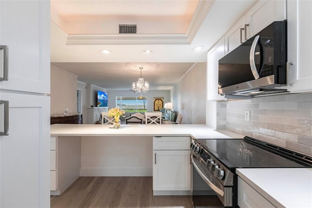 1150 Tarpon Center Dr Unit 1D, Venice, FL 34285 - kitchen with stainless steel appliances, white cabinets, backsplash, light wood-style floors, and recessed lighting