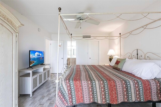 1150 Tarpon Center Dr Unit 1D, Venice, FL 34285 - bedroom with light wood finished floors, connected bathroom, and ceiling fan