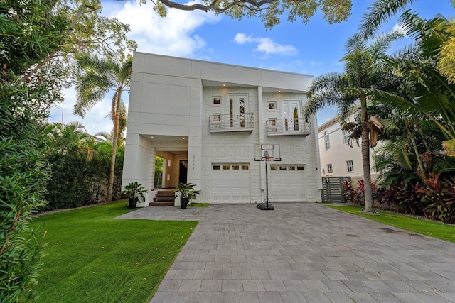 2711 W Trilby Ave, Tampa, FL 33611 - view of front of home with a balcony, a garage, a front yard, and decorative driveway