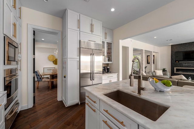 2711 W Trilby Ave, Tampa, FL 33611 - kitchen featuring built in appliances, a warming drawer, open floor plan, light stone countertops, and dark wood-type flooring