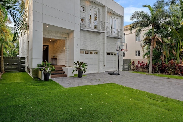 2711 W Trilby Ave, Tampa, FL 33611 - view of front of house with a balcony, an attached garage, and a front yard
