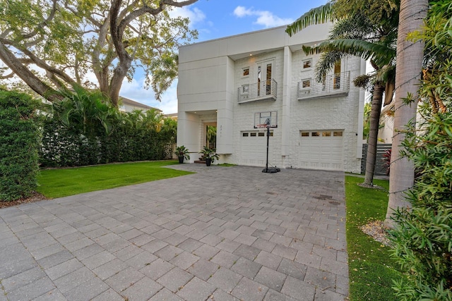 2711 W Trilby Ave, Tampa, FL 33611 - view of front of home with a balcony, an attached garage, decorative driveway, and a front yard